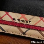 버버리 빈티지 체크 지갑 추천 - A close-up shot of a vintage Burberry wallet resting on a polished wooden table, featuring the iconi...